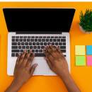 Hands typing on a laptop